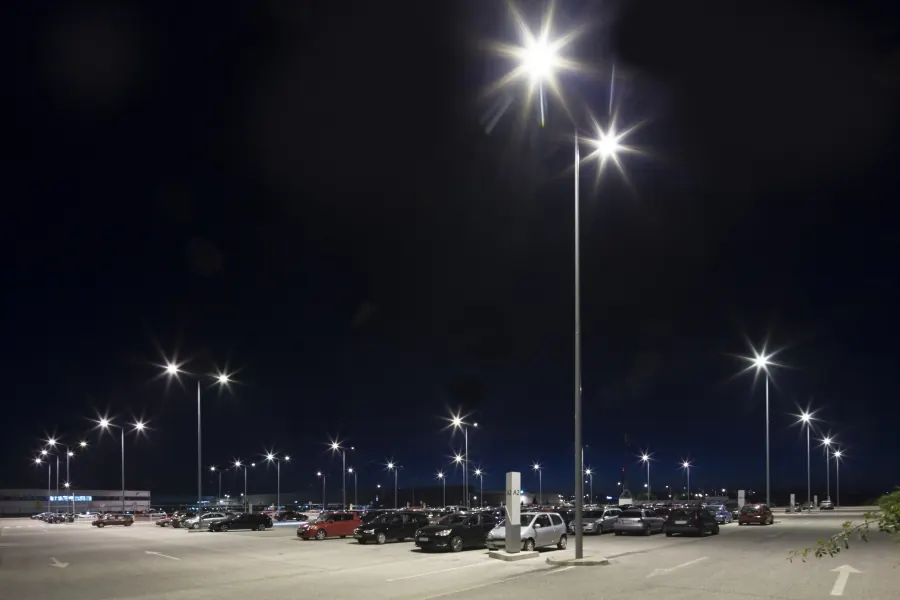 Beleuchteter Parkplatz eines Handelsunternehmens bei Nacht