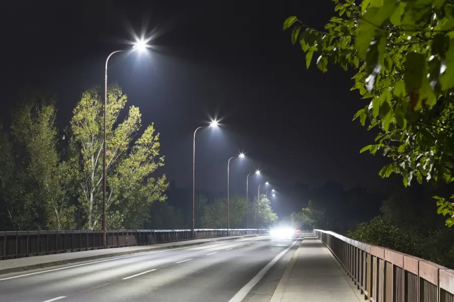 Beleuchtete Straße mit Lichtmasten bei Nacht
